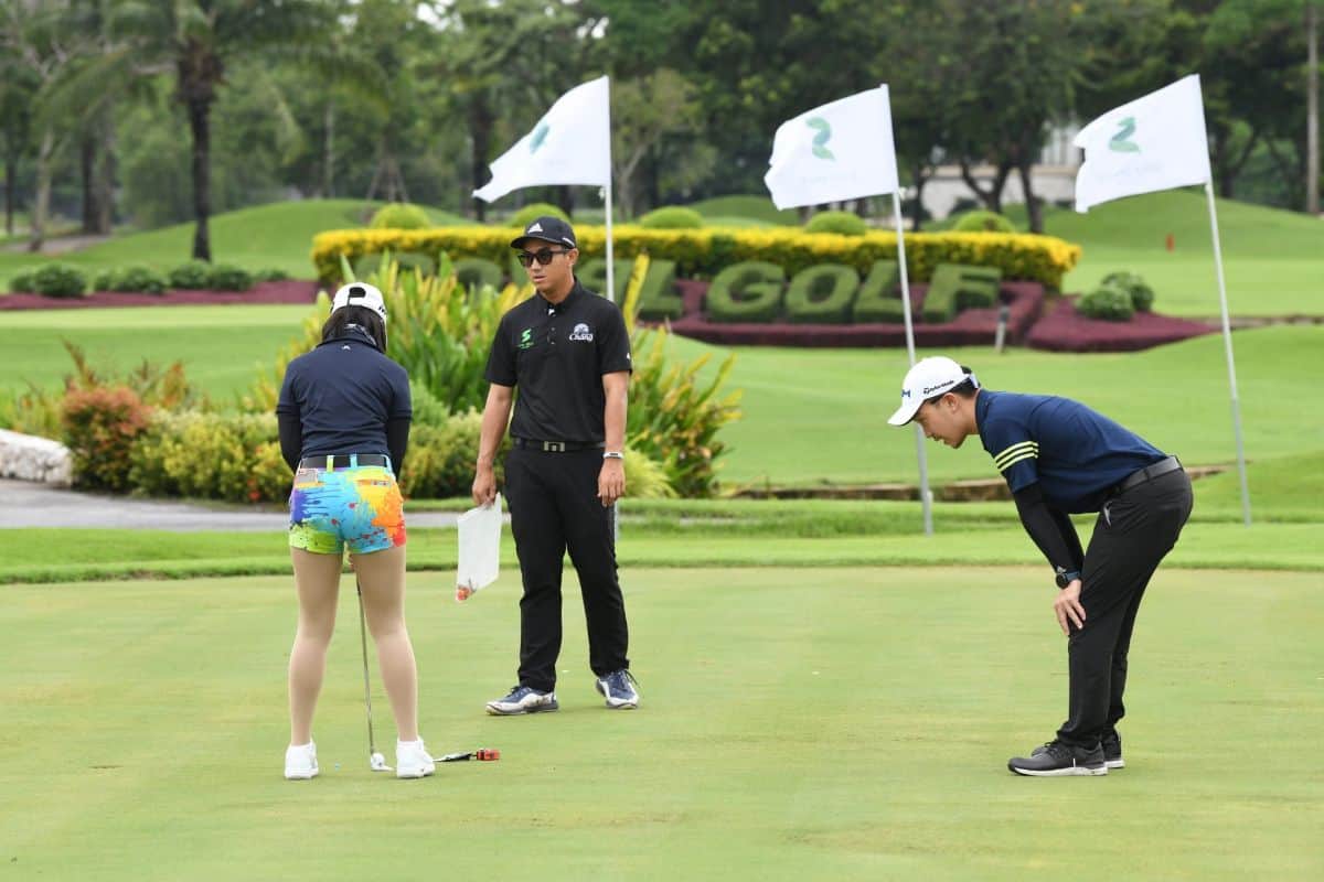 ผู้หญิงหัดตีกอล์ฟฝึกซ้อมวงสวิงในสนามกอล์ฟที่ได้มาตรฐาน